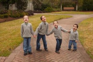 Four young brothers holding hands